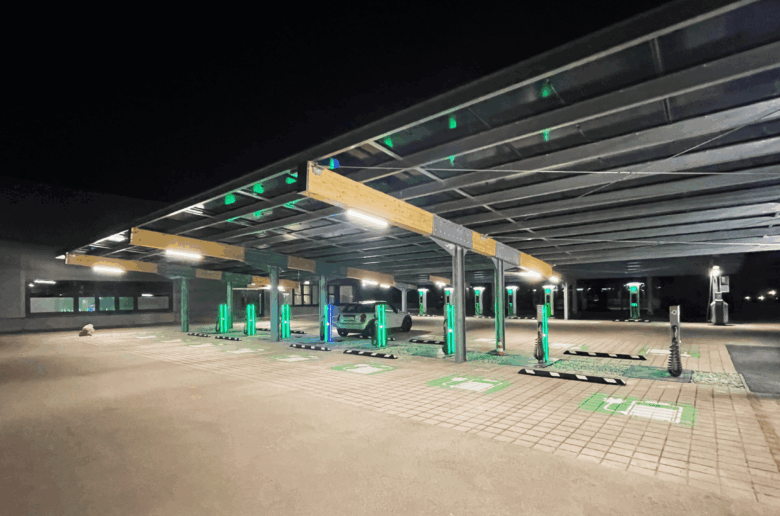 Nachtszene eines Solarcarports mit mehreren freien Ladeplätzen, beleuchteten E-Ladestationen und einem geparkten Elektrofahrzeug.