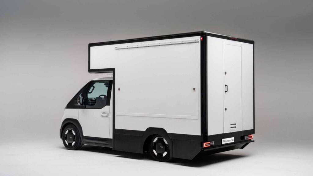 Kia PV5 Chassis Cab mit geschlossenem Kofferaufbau in Studioansicht von vorne schräg.