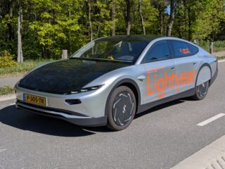 Lightyear-Solarauto mit in Dach und Motorhaube integrierten Photovoltaikmodulen auf einer Straße.