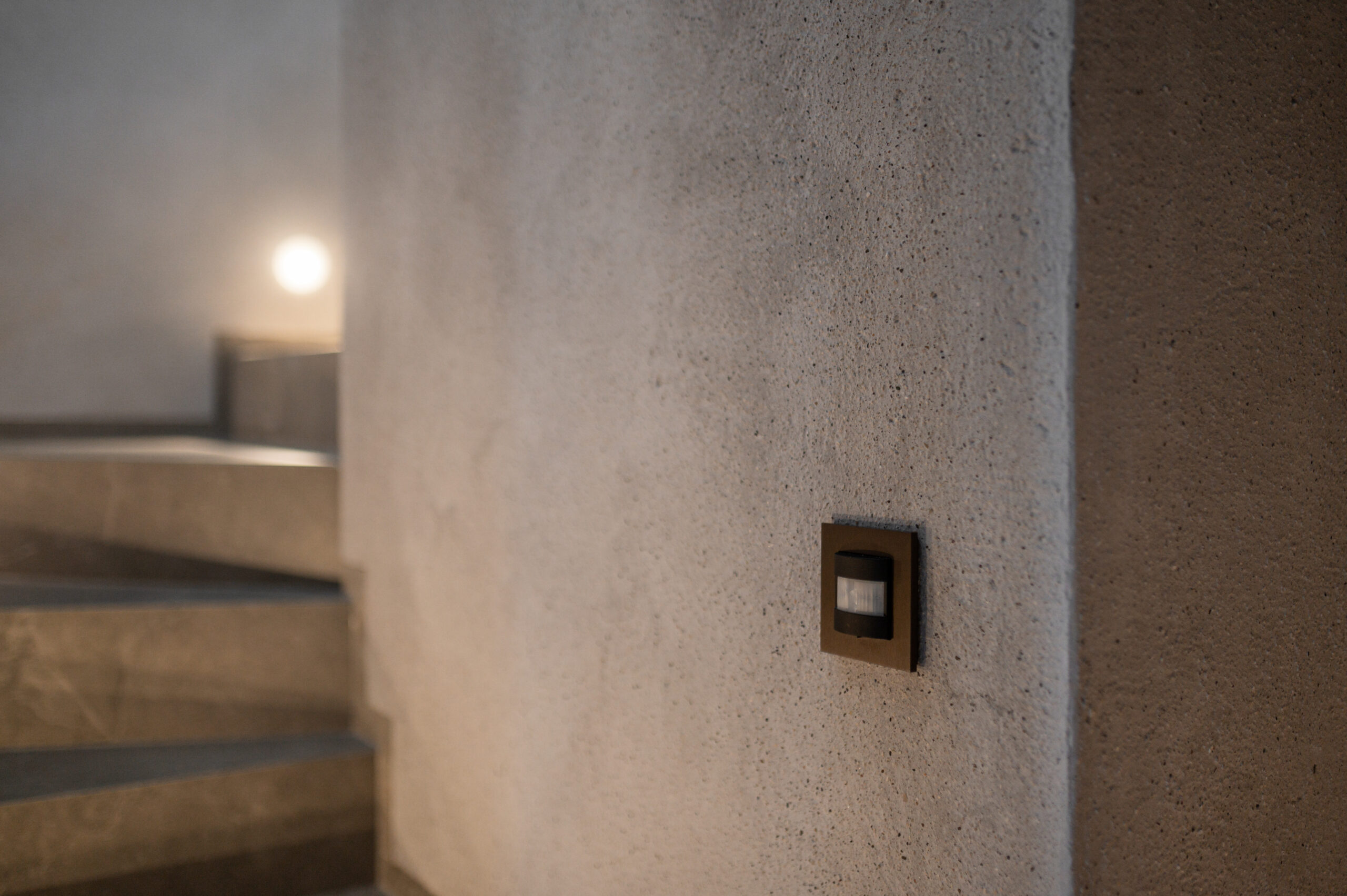 In die Wand integrierter Bewegungsmelder neben einer Treppe zur automatischen Steuerung der Beleuchtung.